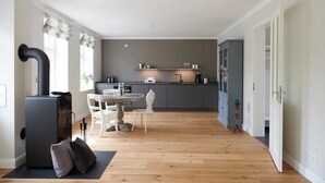 Uma cozinha moderna com área de refeições, fogão embutido e uma janela grande.