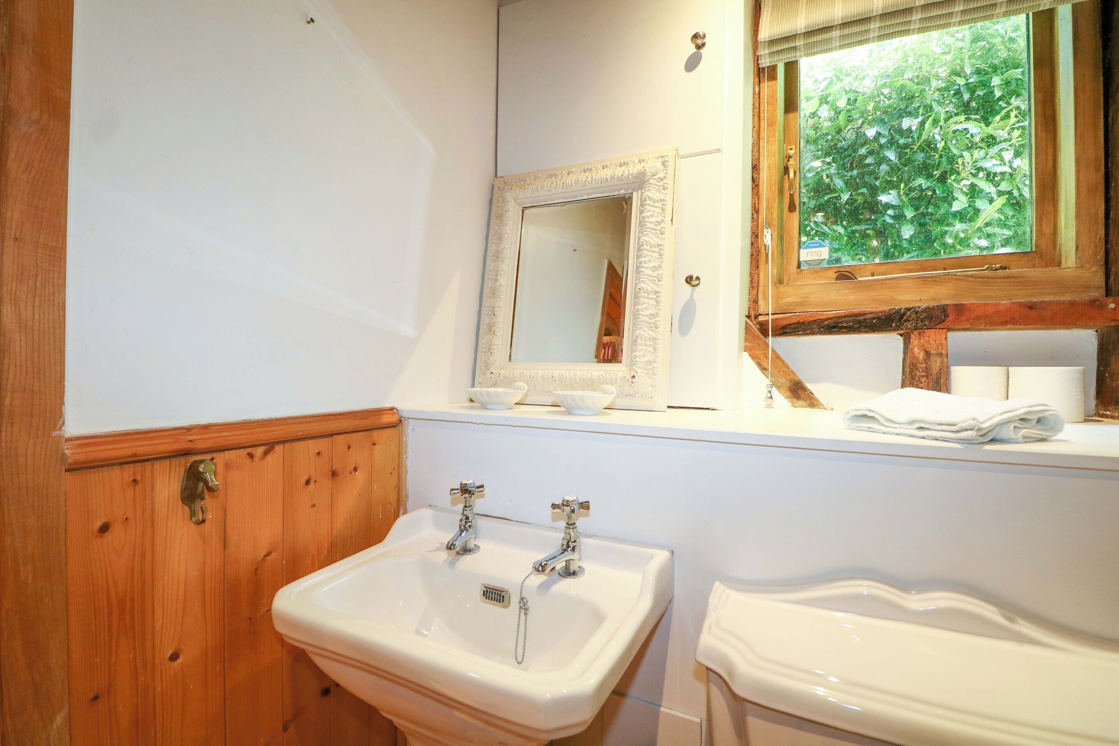 Une salle de bain avec un meuble-lavabo en bois, un évier et un miroir.