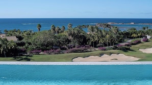 A resort with a pool, palm trees, and a view of the ocean. - PH Azure: 4BR Oceanview Penthouse w/ Private Heated Infinity Pool & Rooftop (Punta Mita)