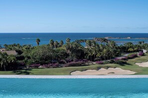 Ein Resort mit Pool, Palmen und Blick auf den Ozean.