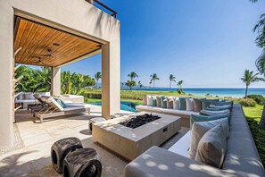 Ein moderner Außenbereich mit Lounge-Möbeln, einem Pool und Blick auf den Ozean.