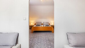 A bedroom with a wooden bed, two bedside lamps, and a patterned carpet.