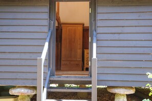 A wooden door leading to a room with a wooden floor and a cabinet. - The Granary (Petworth)