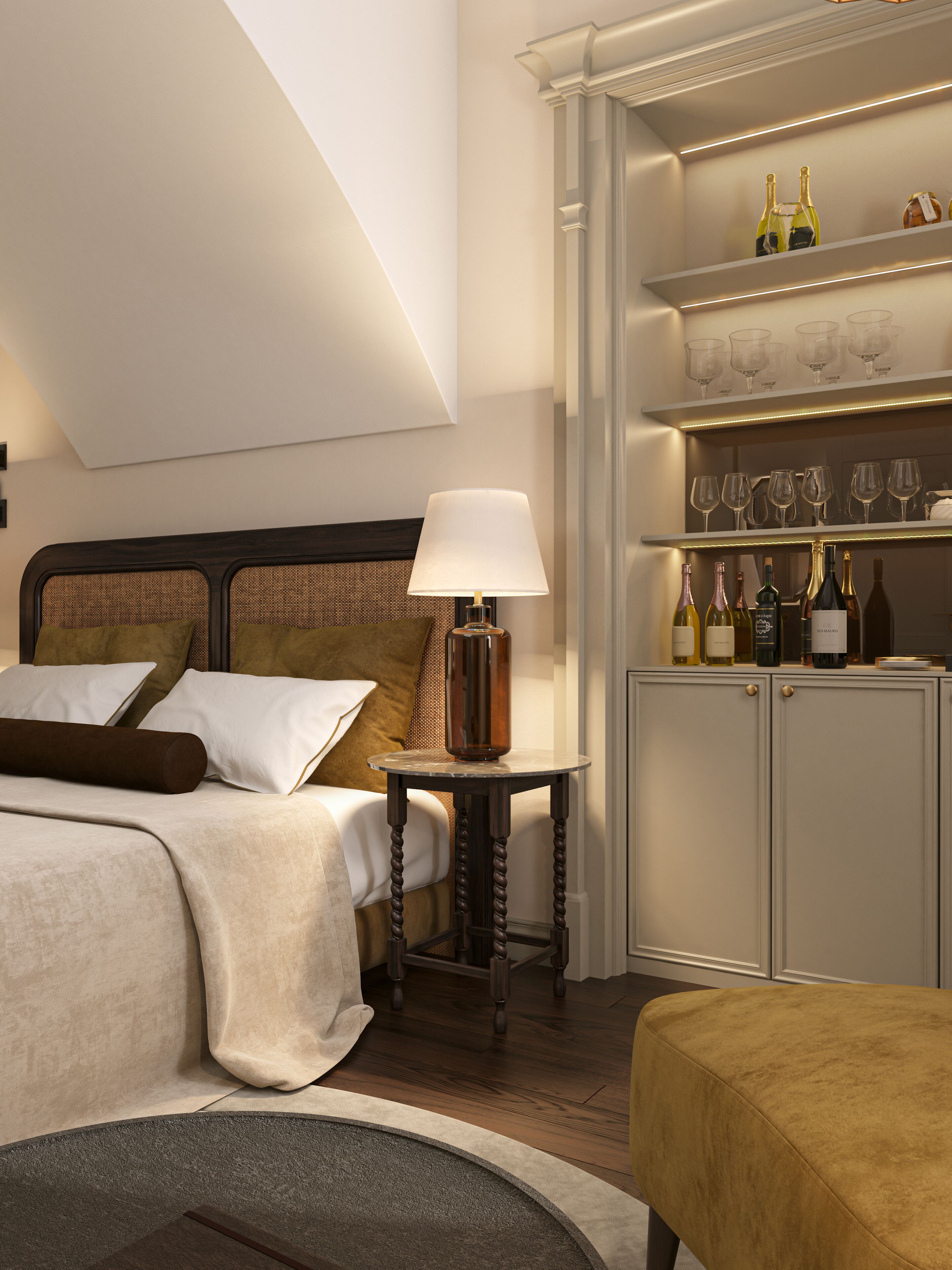 A hotel room with a bed, a bedside table with a lamp, a minibar with wine bottles, and a shelf with glasses.