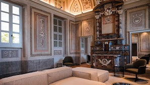 A spacious room with a large sectional sofa, a fireplace, and ornate wall decorations.