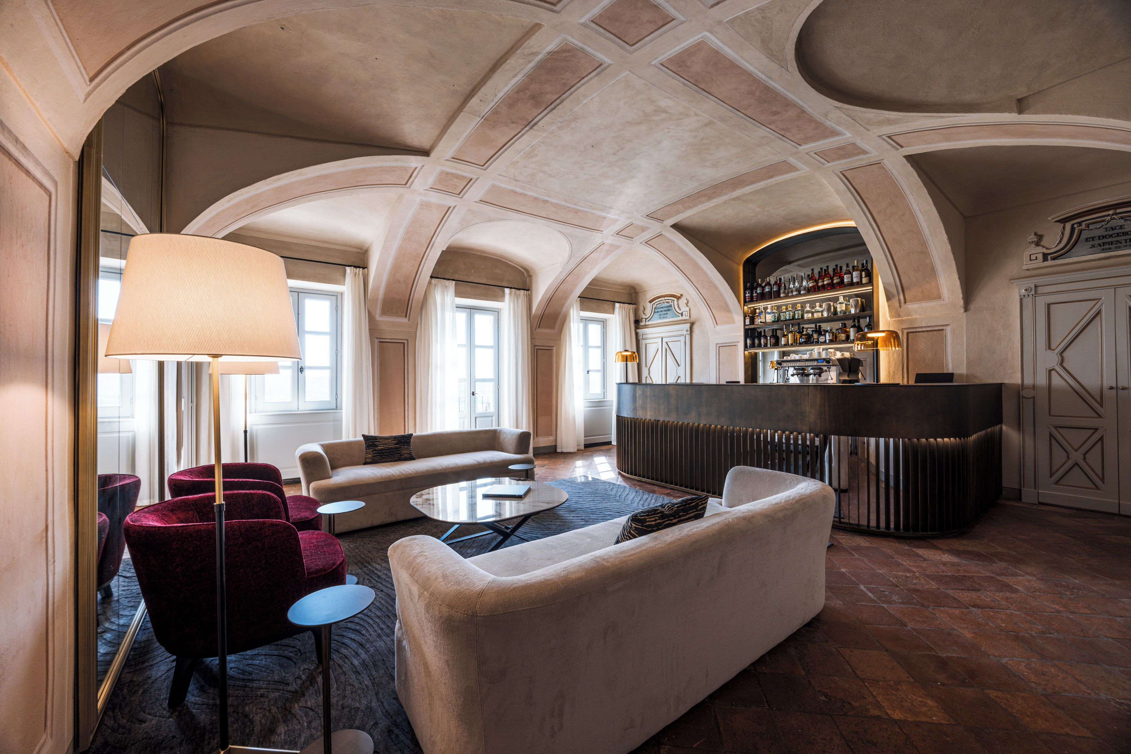Een receptie met gewelfde plafonds, een bar met wijnkaart, en zitgedeeltes.
