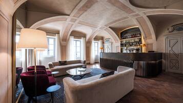 Een receptie met gewelfde plafonds, een bar met wijnkaart, en zitgedeeltes.