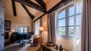 A cozy room with a fireplace, a round table, and a view of the countryside.
