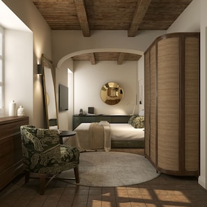 Un dormitorio con cama, una silla, un espejo redondo y un mueble grande de fibras naturales.