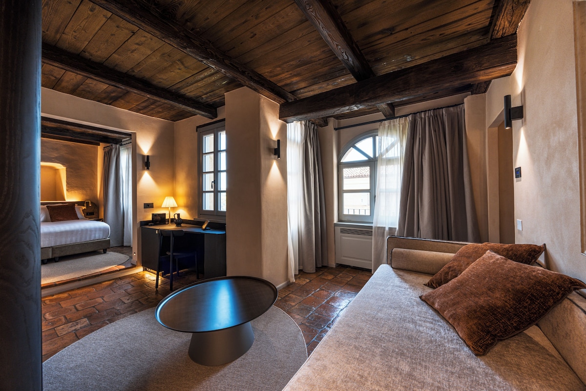 Una habitación acogedora con una cama, un escritorio y un sofá.