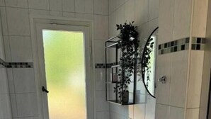 Een kleine badkamer met toilet, wastafel en spiegel.