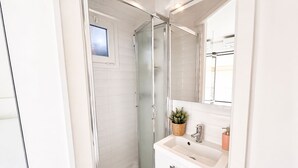 A modern bathroom with a glass shower enclosure, a white sink, and a mirror above the sink. - Joli 2 pi ces Monaco (Monaco)