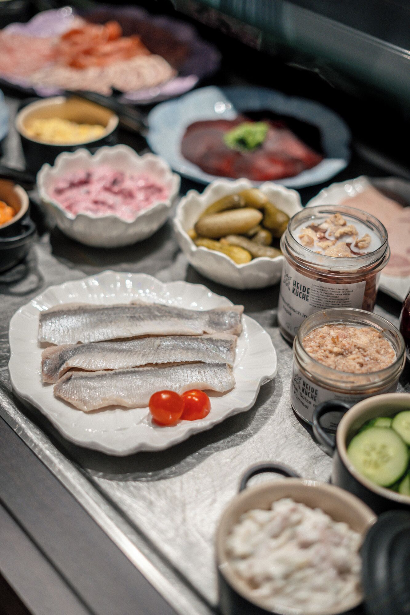 Una variedad de alimentos en una bandeja, como pescado, verduras y salsas.