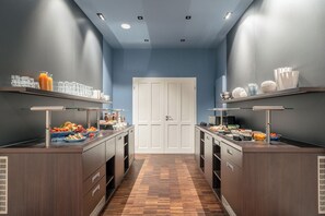 A hotel room with a breakfast bar, a white door, and a wooden floor. - Klostermühle (Groß Meckelsen)