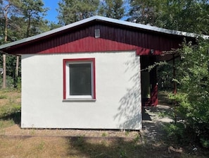 A small, single-story building with a red roof and a white exterior.