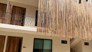 Een gebouw met een balkon, een groot raam en een houten deur.