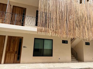 Ein Gebäude mit Balkon, großem Fenster und Holztür.