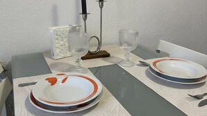 Uma mesa de jantar posta com pratos, talheres, copos e velas.