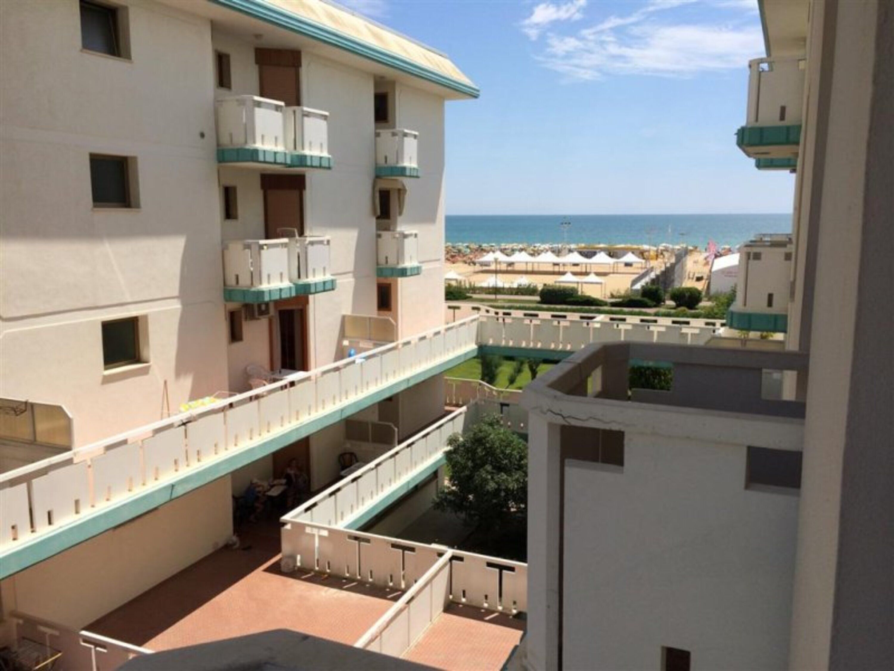 Un hôtel à plusieurs étages doté de balcons, d’un espace piscine et offrant une vue sur la plage.