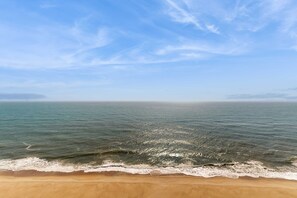 Ein Strand mit blauem Himmel und ruhigem Meer.
