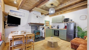 Un espacio habitable compacto con comedor, cocina y zona de estar.
