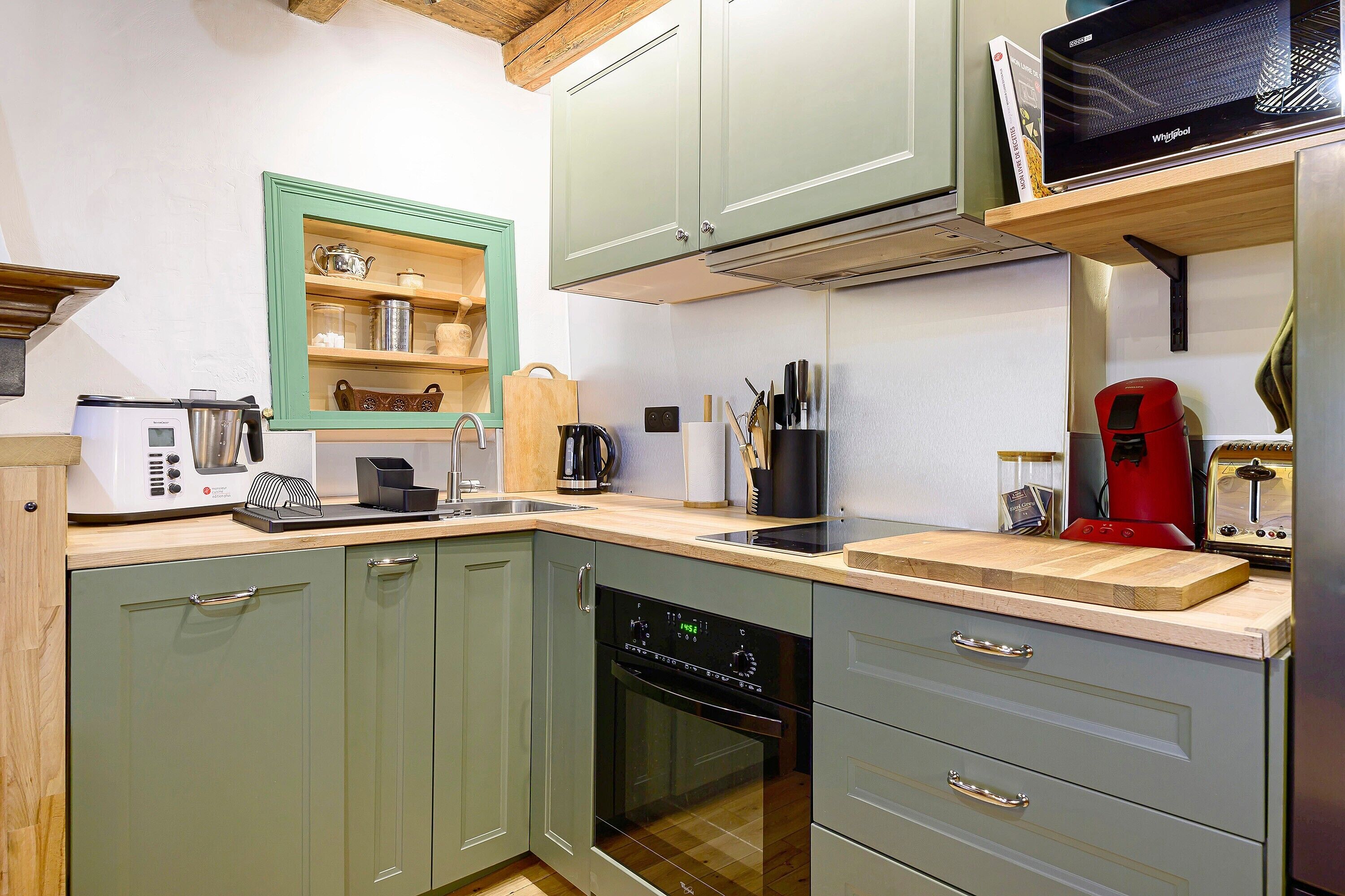 A kitchen with a microwave, toaster, coffee maker, and a dishwasher.