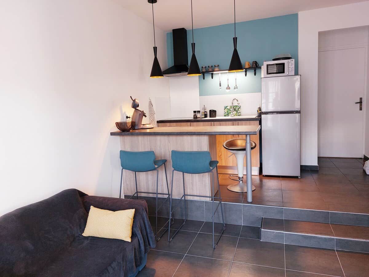 Una cocina moderna con barra, una mesa de comedor y un sofá en la sala de estar.