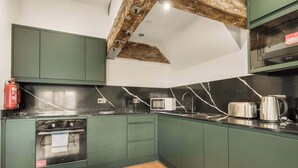Una cucina con mobili verdi, un forno a microonde, un tostapane e un bollitore.