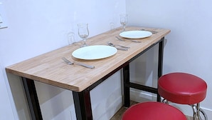 A dining table with two plates, cutlery, and glasses, flanked by red stools. - Private, Modern Casita, Coffee Bar, Wet Bar (Page)