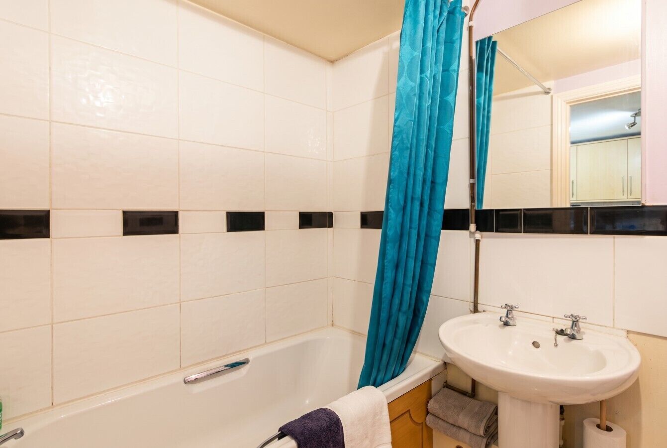 Un baño con bañera, lavamanos y espejo.