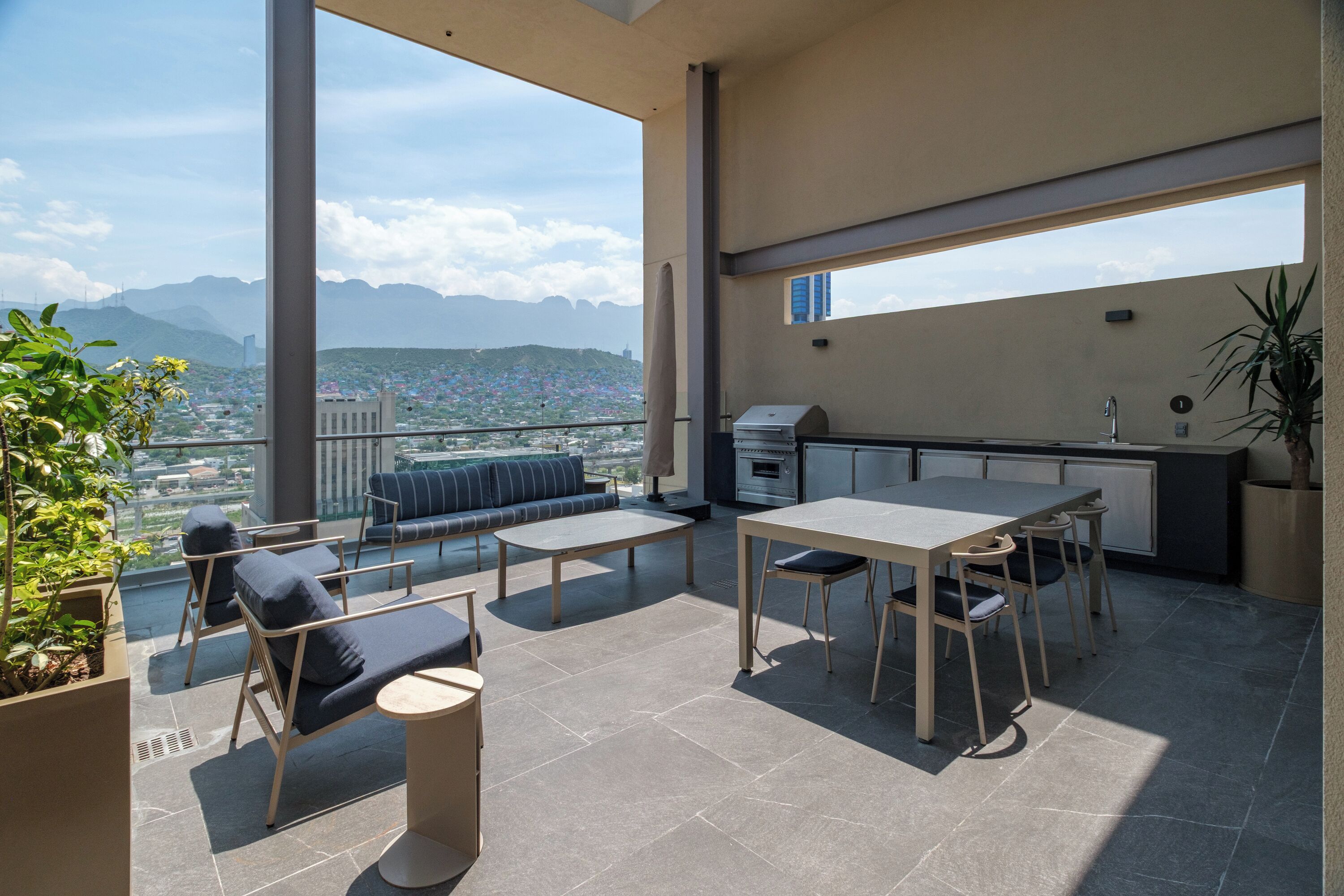 Un balcón con comedor, asientos y vistas de la ciudad.