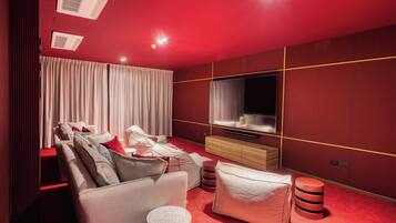 A modern living room with a red carpet, a sofa set, a TV, and a wooden cabinet.