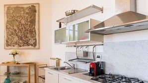 Een moderne keuken met een gasfornuis, een roestvrijstalen spoelbak en een inbouwoven.
