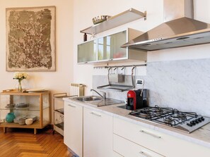 Eine moderne Küche mit Gasherd, Edelstahlspüle und integriertem Backofen.