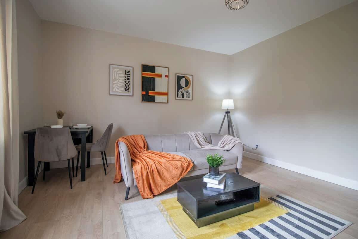 Un saló modern amb un sofà, taula de centre i obra d'art a la paret.