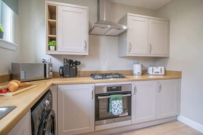 Eine Küche mit Geschirrspüler, Backofen, Toaster und Gasherd.