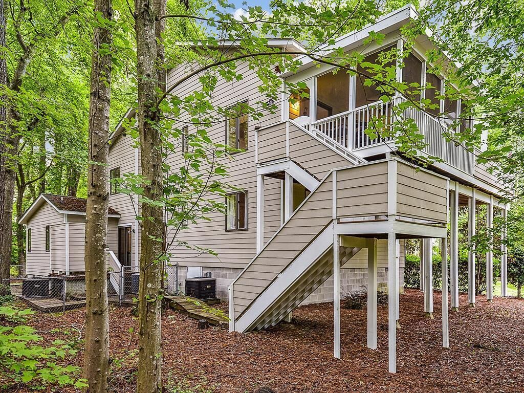 A two-story house with a front porch, a staircase, and a covered deck.