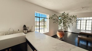 Une cuisine moderne avec une grande fenêtre, un évier et une plante en pot.