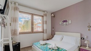 A bedroom with a bed, a window, a nightstand, and a lamp.