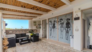 A spacious patio with outdoor furniture, a tiled floor, and a large wall mural.