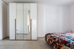 A bedroom with a bed, a wardrobe, and a mirror. - Dimora Fico d'India by BarbarHouse (Lecce)
