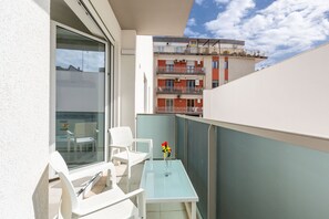 A balcony with white chairs, a small table, and a vase of flowers. - Dimora Fico d'India by BarbarHouse (Lecce)