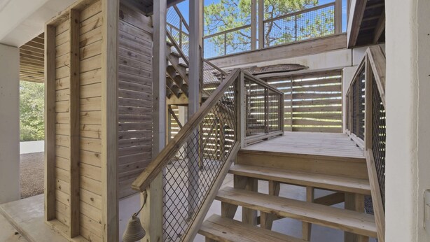 Una scala in legno con ringhiere metalliche che conduce a un piano superiore.