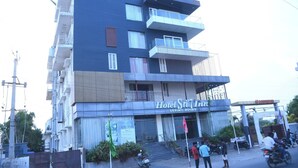 A multi-story building with a sign for 'Hotel Sri 7 Inn' indicating luxury rooms.