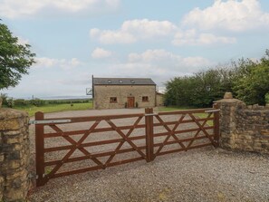 A stone building with a gravel driveway and a wooden gate. - The Gallops (Barry)