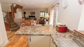 A kitchen with a granite countertop, a toaster, and a wooden staircase. - The Gallops (Barry)