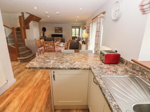 A kitchen with a granite countertop, a toaster, and a wooden staircase. - The Gallops (Barry)