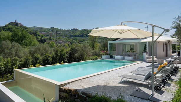 A swimming pool with a view of a hill, outdoor seating, and a covered area. - Villa Lunezia 6, Emma Villas (Aulla)