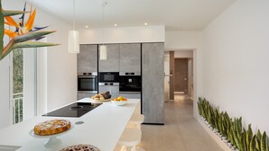 A modern kitchen with a central island, built-in appliances, and a view of the outdoors. - Villa Lunezia 6, Emma Villas (Aulla)