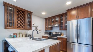 A kitchen with wooden cabinets, stainless steel appliances, a marble countertop, and a built-in sink. - Luxury 3-Bedroom, Heart of Telluride, Mtn Views, 3 min walk to Gondola & Trails (Telluride)